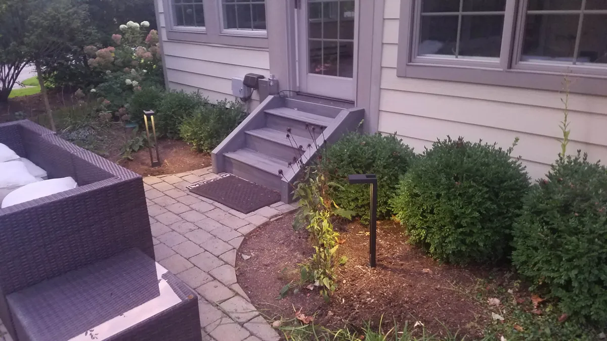 Shrubs and a small tree planted along a front walkway by Lee's Lawn & Landscaping